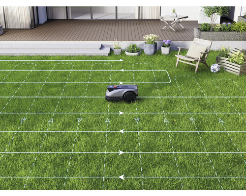 Ein Rasenmähroboter mäht einen Rasen in einem Garten mit Terrasse.
