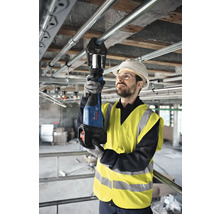 Handwerker bei der Verwendung einer Rohrzange zum Verpressen von Rohren auf einer Baustelle.
