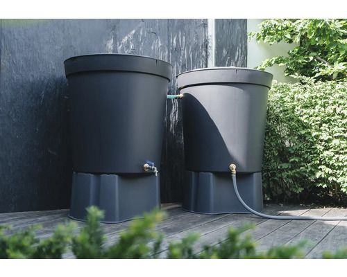 Zwei dunkelgraue Regentonnen mit Wasserhahn auf einer Holzterrasse