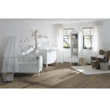 Helles Kinderzimmer mit Kinderbett, Wickelkommode, Regal und Sessel