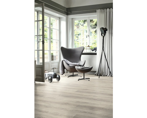 Heller Wohnraum mit Sessel, Stehlampe, Holzboden und großem Fenster