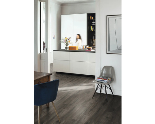 Heller Raum mit Küche, Esstisch und Stuhl auf dunklem Holzboden.