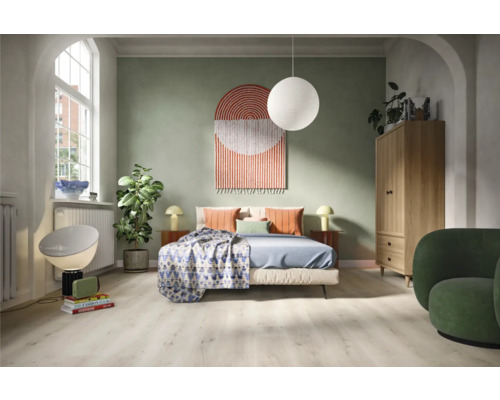 Schlafzimmer mit Bett, Schrank, Sessel und dekorativen Elementen für ein gemütliches Ambiente