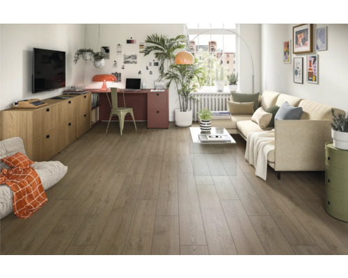 Heller Wohnraum mit Holzboden, Sofa, Schreibtisch und Dekorationen für ein gemütliches Ambiente.