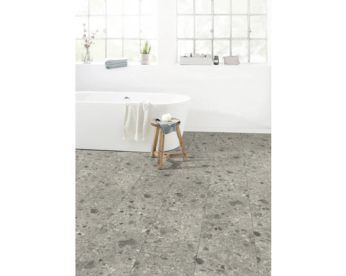 Badezimmer mit freistehender Badewanne, Holzhocker und Bodenfliesen in Steinoptik