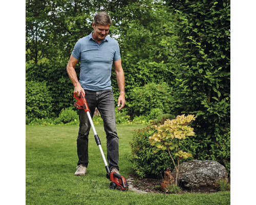 Mann arbeitet mit einem Akku-Rasenkantenschneider im Garten, um Rasenkanten zu schneiden.