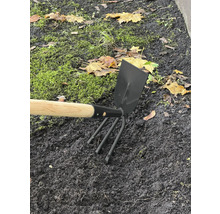 Gartengerät mit Holzstiel und Dreizackzinken im Beet