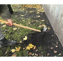 Gartenarbeit mit einer Kombihacke zur Bodenbearbeitung