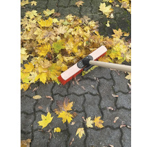 Laubbesen auf Pflastersteinen mit Herbstlaub