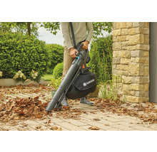 Eine Person benutzt einen Gardena Akku Laubsauger, um Blätter aufzusammeln.