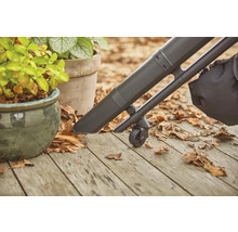 Laubsauger im Einsatz auf einer Holzterrasse mit Herbstlaub