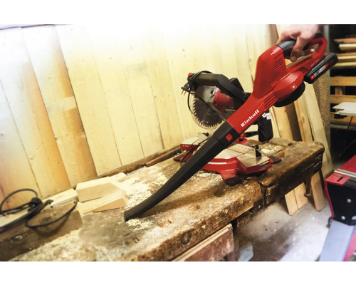 Einhell Akku-Laubbläser auf einer Werkbank mit einer Kreissäge im Hintergrund