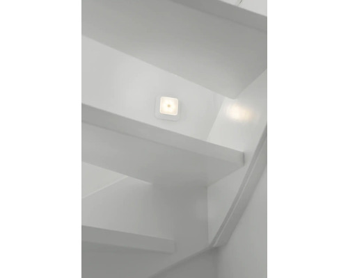 Treppenhaus mit Treppenstufen und einer quadratischen LED-Wandleuchte