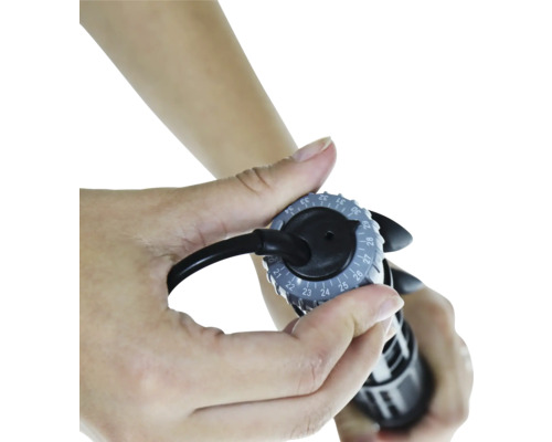 Nahaufnahme einer Hand, die den Druck einer Fahrradpumpe einstellt.