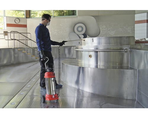 Mann mit Sprühgerät zur Desinfektion in einem Schwimmbad