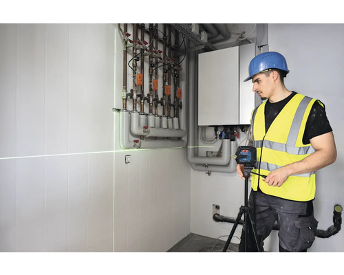 Handwerker verwendet einen Linienlaser zur Ausrichtung in einem Heizungsraum.