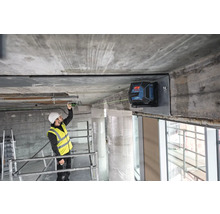 Ein Bauarbeiter benutzt einen Linienlaser zur Ausrichtung an einer Baustelle.