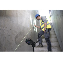 Ein Bauarbeiter verwendet einen Linienlaser zur Ausrichtung auf einer Betonwand.