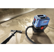 Blauer und schwarzer Nass-Trockensauger von Bosch reinigt einen gefliesten Boden