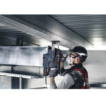 Bohrarbeiten an einer Betondecke mit einem Bohrhammer und Bohrständer durch einen Handwerker.