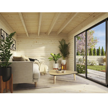 Helle Holzhütte mit Sofa, Tisch, Pflanzen und großem Fenster mit Blick in den Garten.