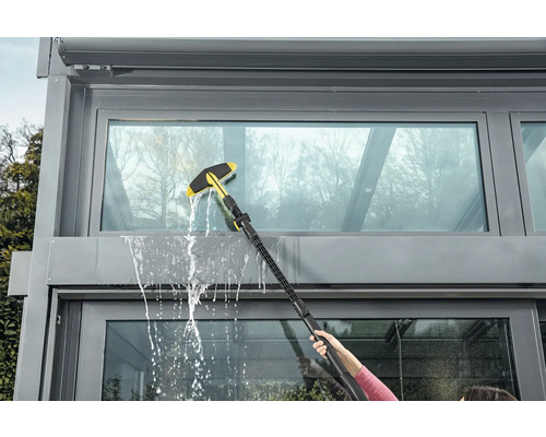 Fensterreinigung mit Fensterwischer an einem Wintergarten