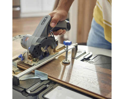 Eine Person schneidet ein Holzbrett mit einer Handkreissäge.