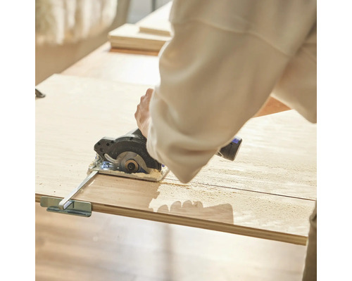 Eine Person schneidet Holz mit einer Kreissäge.