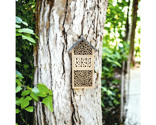 Insektenhotel aus Holz an einem Baumstamm