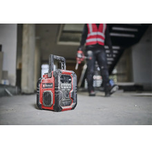 Ein Baustellenradio der Marke Einhell steht auf dem Boden eines Rohbaus.