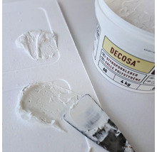 Decosa Styroporkleber mit Spachtel und Kleberresten auf einer Palette