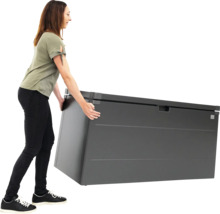 Eine Frau schiebt eine graue Gartenbox.