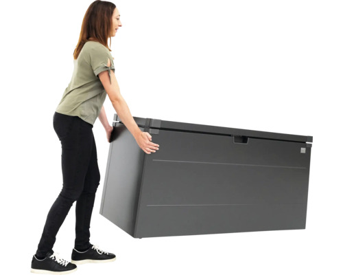 Eine Frau schiebt eine graue Gartenbox.
