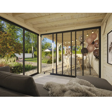 Helles Interieur eines Gartenhauses mit Glasschiebetüren und Blick auf den Garten
