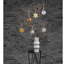 Dekorativer Zweig mit Sternen und Kugeln in einer Vase auf einem Tisch