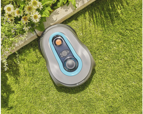 Gardena Mähroboter auf Rasenfläche in der Nähe eines Blumenbeets