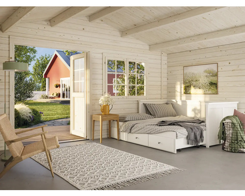 Innenansicht eines hellen Holzhauses mit Bett, Teppich und Blick in den Garten