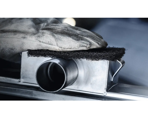 Metallrohr wird mit einem Schleifvlies bearbeitet, geschützt durch einen Arbeitshandschuh.