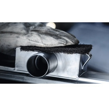 Eine Hand mit Arbeitshandschuh hält einen Schleifschwamm auf einem Metallrohr.