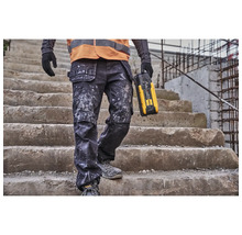 Handwerker mit Arbeitshose und Baustellenradio auf einer Treppe