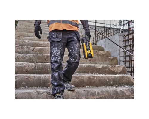 Handwerker mit Arbeitshose und Baustellenradio auf einer Treppe