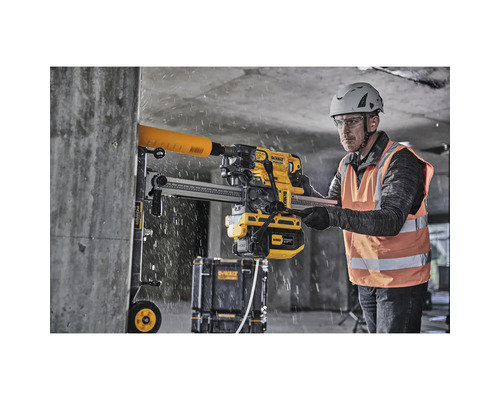 Mann bohrt mit einer DeWalt Bohrmaschine ein Loch in eine Betonwand.