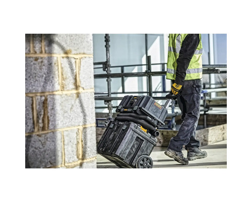 Bauarbeiter transportiert Nass-Trockensauger mit Rollen.