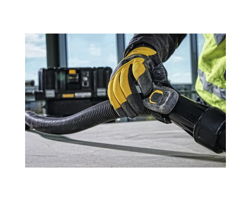 Eine Hand mit Handschuh hält einen Staubsaugerschlauch.