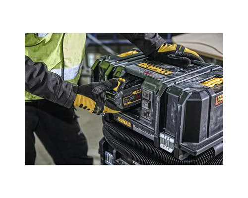 Eine Person setzt einen Akku in einen Dewalt Akku-Staubsauger ein.