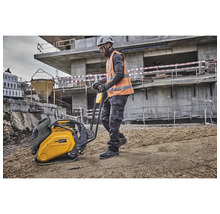 Ein Bauarbeiter bedient eine Rüttelplatte auf einer Baustelle.