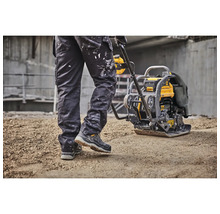 Ein Bauarbeiter bedient eine DeWalt Rüttelplatte zum Verdichten von Untergründen.
