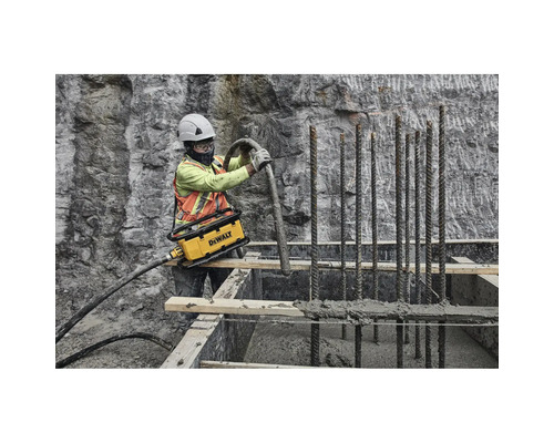 Bauarbeiter verdichtet Beton mit einem Betonverdichter von DeWalt auf einer Baustelle.