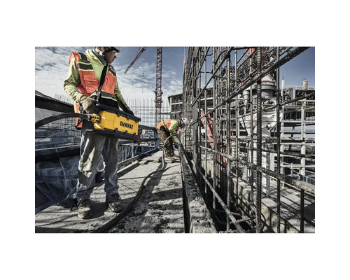 Bauarbeiter verwenden einen Betonrüttler auf einer Baustelle.