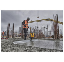 Ein Bauarbeiter verwendet eine Betonabziehmaschine auf einer Baustelle, um Beton zu glätten.